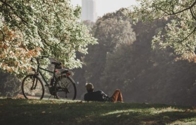man relaxing next to bike in park