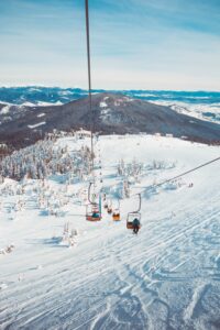 skiers riding chairlift up mountain