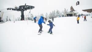 parent snowboarding with kid